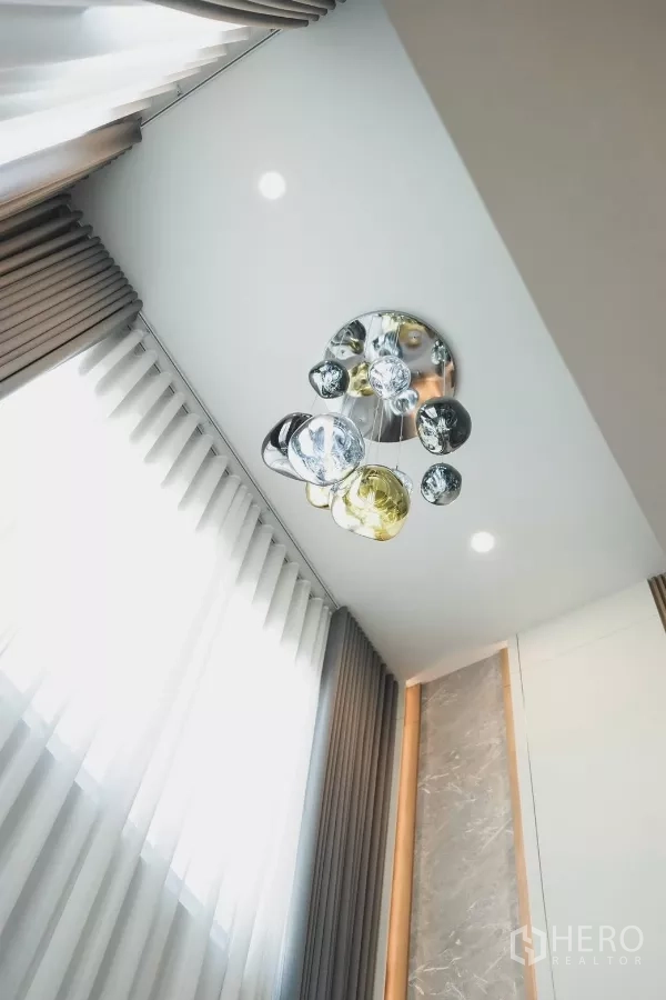 Detached House for rent in Bang Phli, Samut Prakan - Designer pendant chandelier on a high ceiling with full-height curtains.