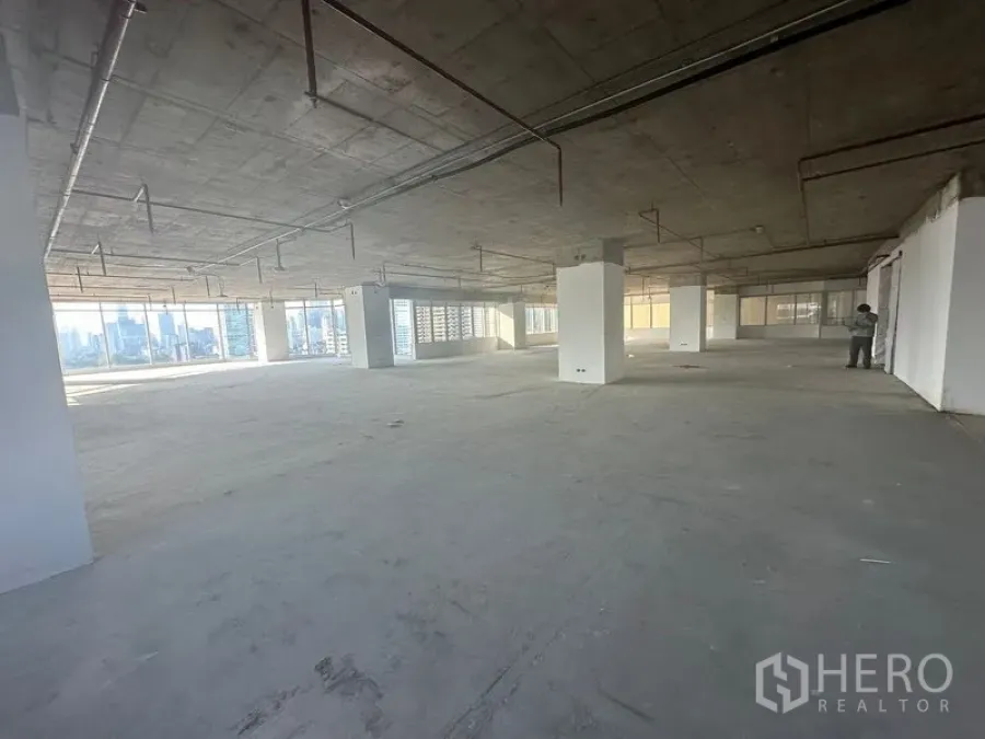 办公空间 出租在Watthana, Bangkok - 开放式办公，多个立柱与环幕窗，视野通向城市。