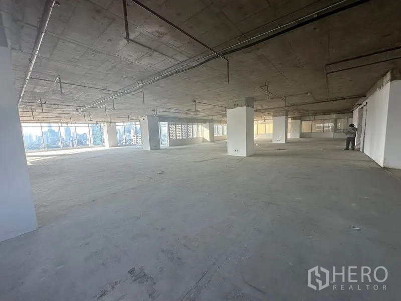 办公空间 出租在Watthana, Bangkok - 开放式办公，多个立柱与环幕窗，视野通向城市。