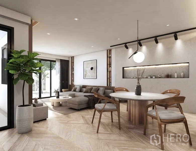 Detached House for rent in Watthana, Bangkok - Open-plan living and dining area with herringbone wood floors, round table, and sliding glass doors to the patio.
