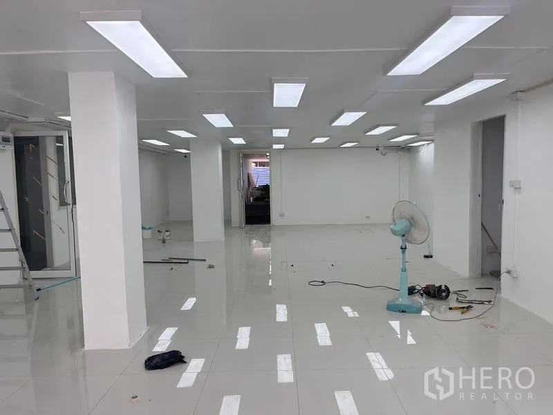 Retail Space for rent in Khlong Toei, Bangkok - Open-plan unit under bright LED panels during fit-out, tools on the floor.