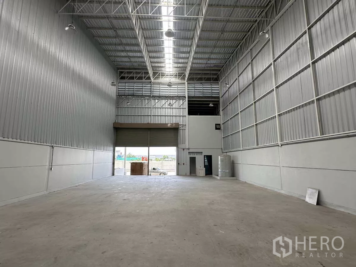 Warehouse for rent in Wang Noi, Phra Nakhon Si Ayutthaya - Open warehouse bay looking toward the loading door with high-bay lighting and ventilation.