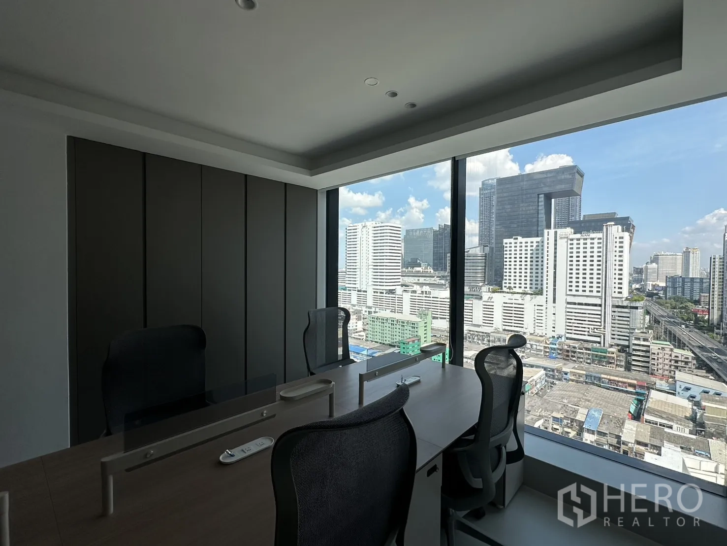 Office Space for rent in Din Daeng, Bangkok - Small team office with workstations facing a large window and city skyline.