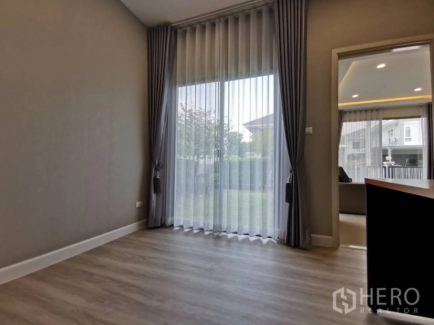 Detached House for rent in Bang Phli, Samut Prakan - Ground-floor room opening to the garden via sliding glass doors with sheer curtains.
