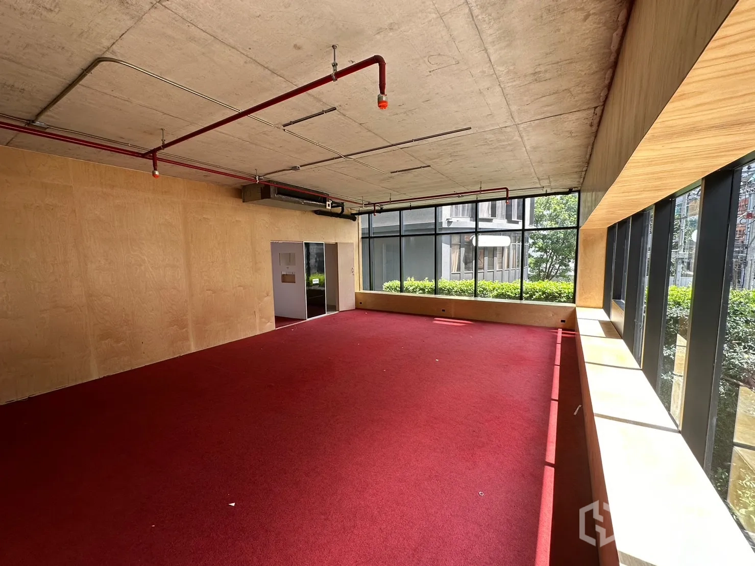 Retail Space for rent in Watthana, Bangkok - Upper floor open-plan area with red carpet, plywood walls and floor-to-ceiling windows.