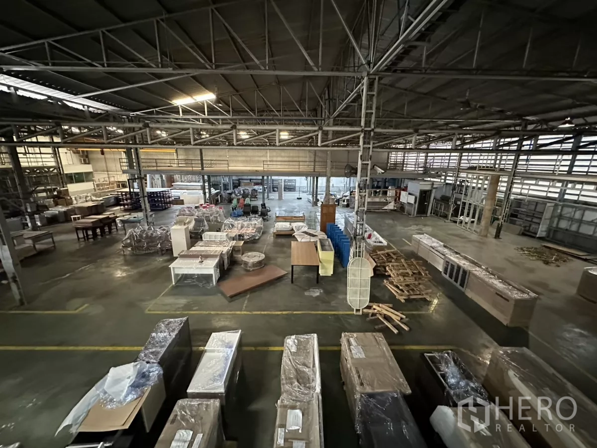 Warehouse for rent in Yan Nawa, Bangkok - Bird’s-eye view of main floor with packed goods and assembly tables.
