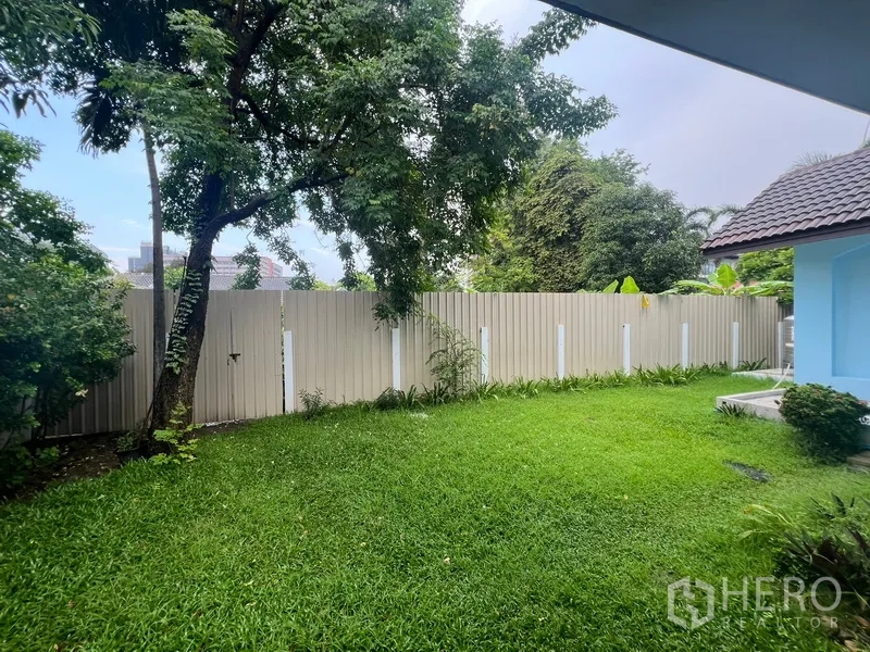 Detached House for rent in Bang Na, Bangkok - Private backyard lawn with trees and a high fence