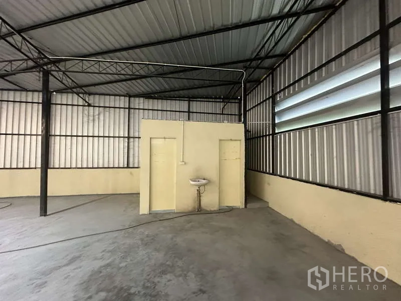 货栈 出租在Pak Kret, Nonthaburi - 仓库角落的两间卫生间与壁挂洗手池。