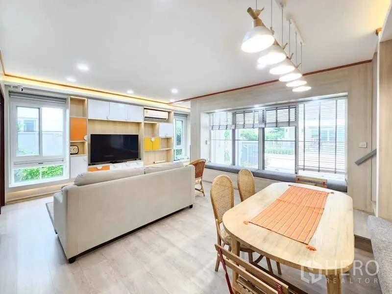 Detached House for rent or sale in Prawet, Bangkok - Open-plan living and dining room with large windows and pendant lighting.