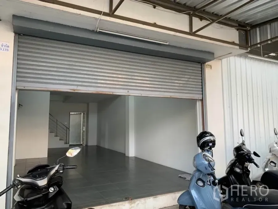 Shophouse for sale in Lat Phrao, Bangkok - Wide shophouse frontage in Lat Phrao with roller shutter and tiled shop floor.