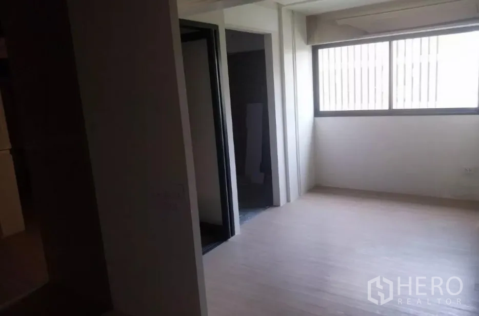 Retail Space for rent - Corner space with a large window and doorway, natural light on light wood floors.