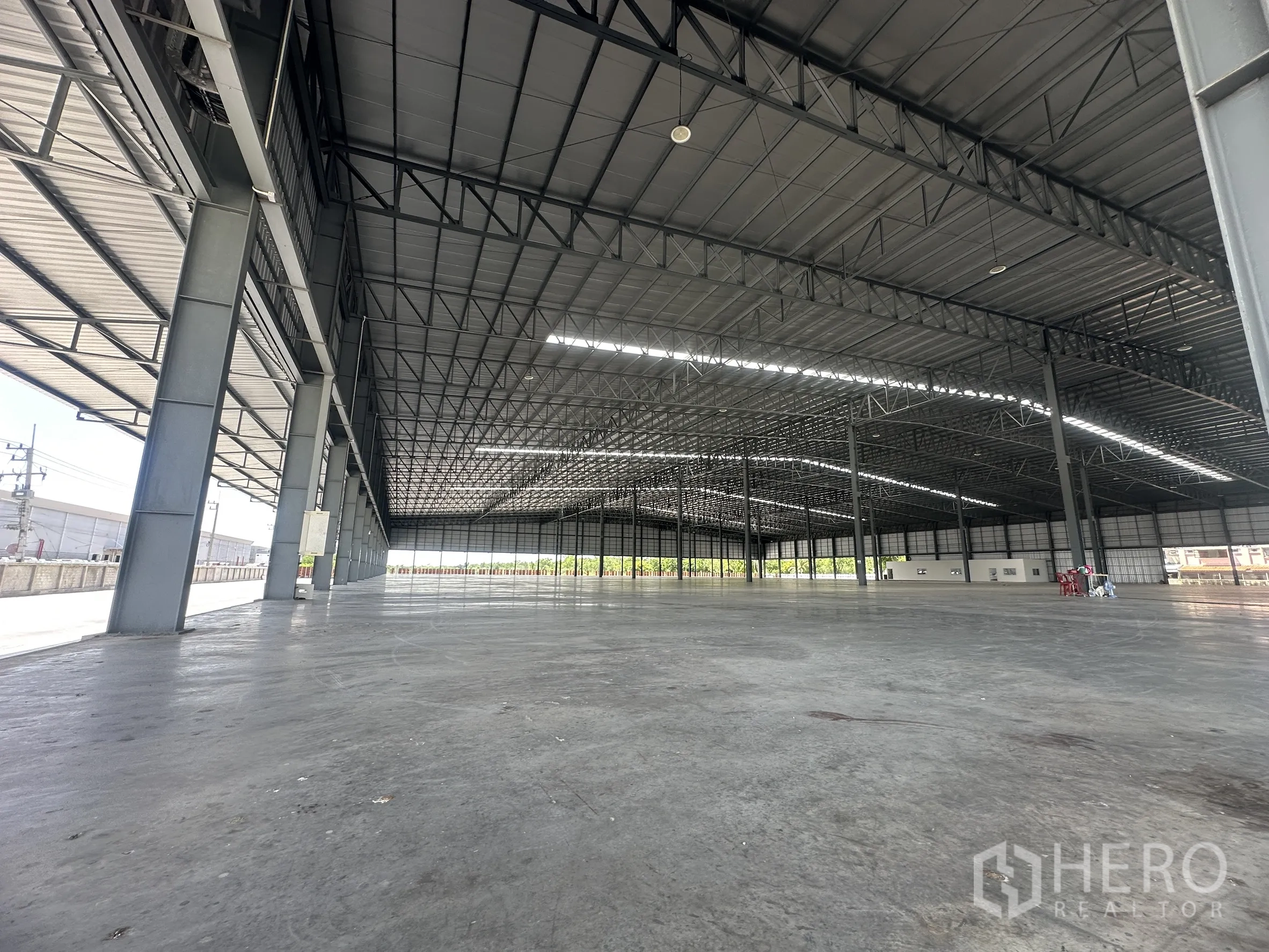 Warehouse for rent in Wang Noi, Phra Nakhon Si Ayutthaya - Covered loading area beneath a high roof with smooth concrete floor.