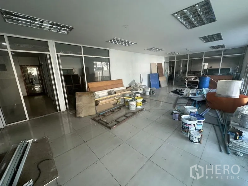 Warehouse for rent in Saphan Sung, Bangkok - Ground-floor workspace with construction materials and tools.