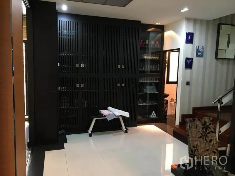 独立式住宅 出租在Khlong Toei, Bangkok - 走廊区，深色内置柜、玻璃展示架与楼梯。