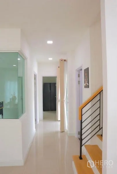 独立式住宅 出租在Bang Phli, Samut Prakan - 走廊与楼梯，旁有玻璃隔断的空间。