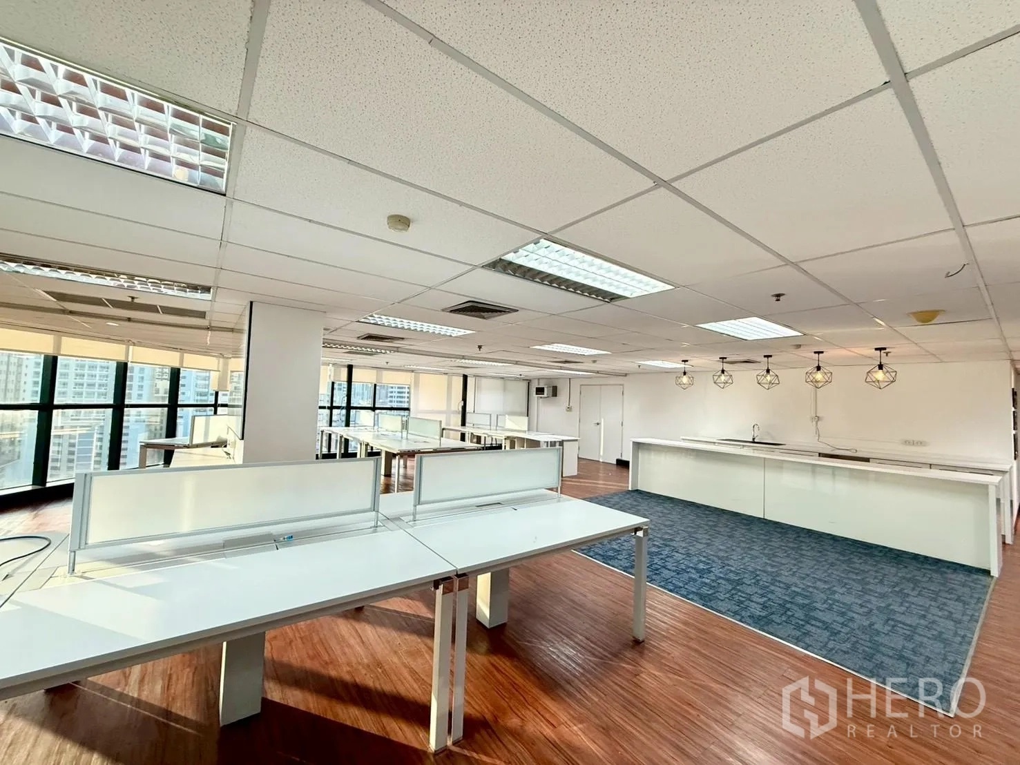 Office Space for rent in Watthana, Bangkok - Workstations near corner windows with city outlooks and a pantry area with pendant lights.