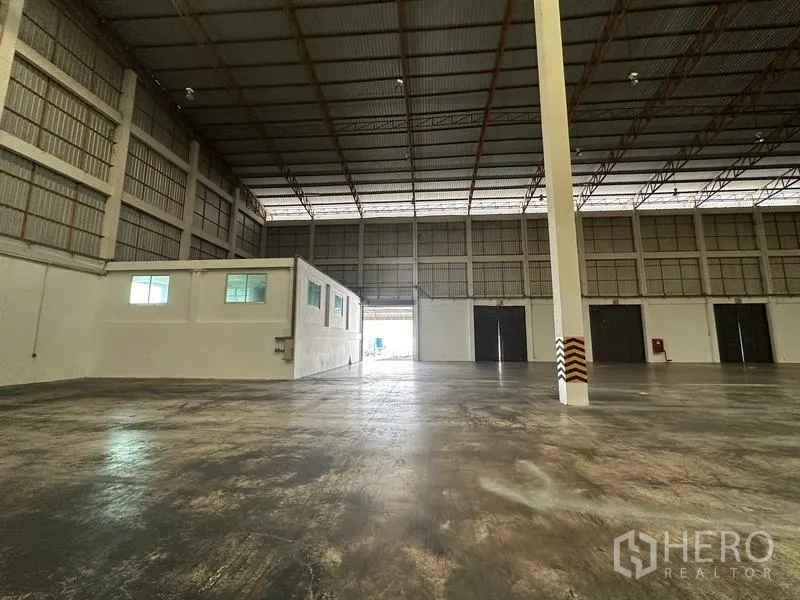Warehouse for rent in Phra Nakhon Si Ayutthaya - Warehouse interior showing small internal office, roller doors and high walls.