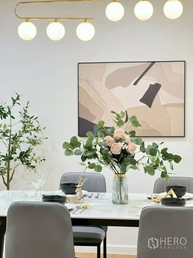 Detached House for rent in Huai Khwang, Bangkok - Artwork and pendant chandelier above a dining table with floral arrangement.