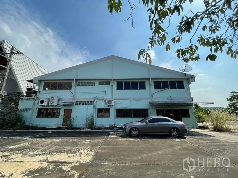 Warehouse for rent or sale in Bang Bon, Bangkok - Rear facade of the warehouse with parking space and exterior air-conditioning units.