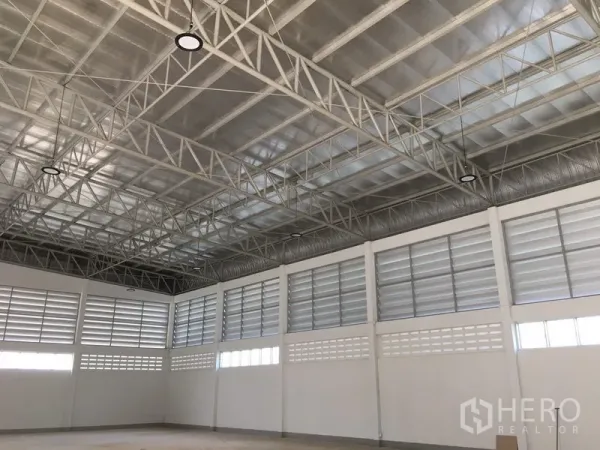 คลังสินค้า ให้เช่าในNong Chok, Bangkok - พื้นโกดังโล่งกว้าง โครงหลังคาโลหะ ไฟไฮเบย์ และช่องลมต่อเนื่องรอบอาคาร