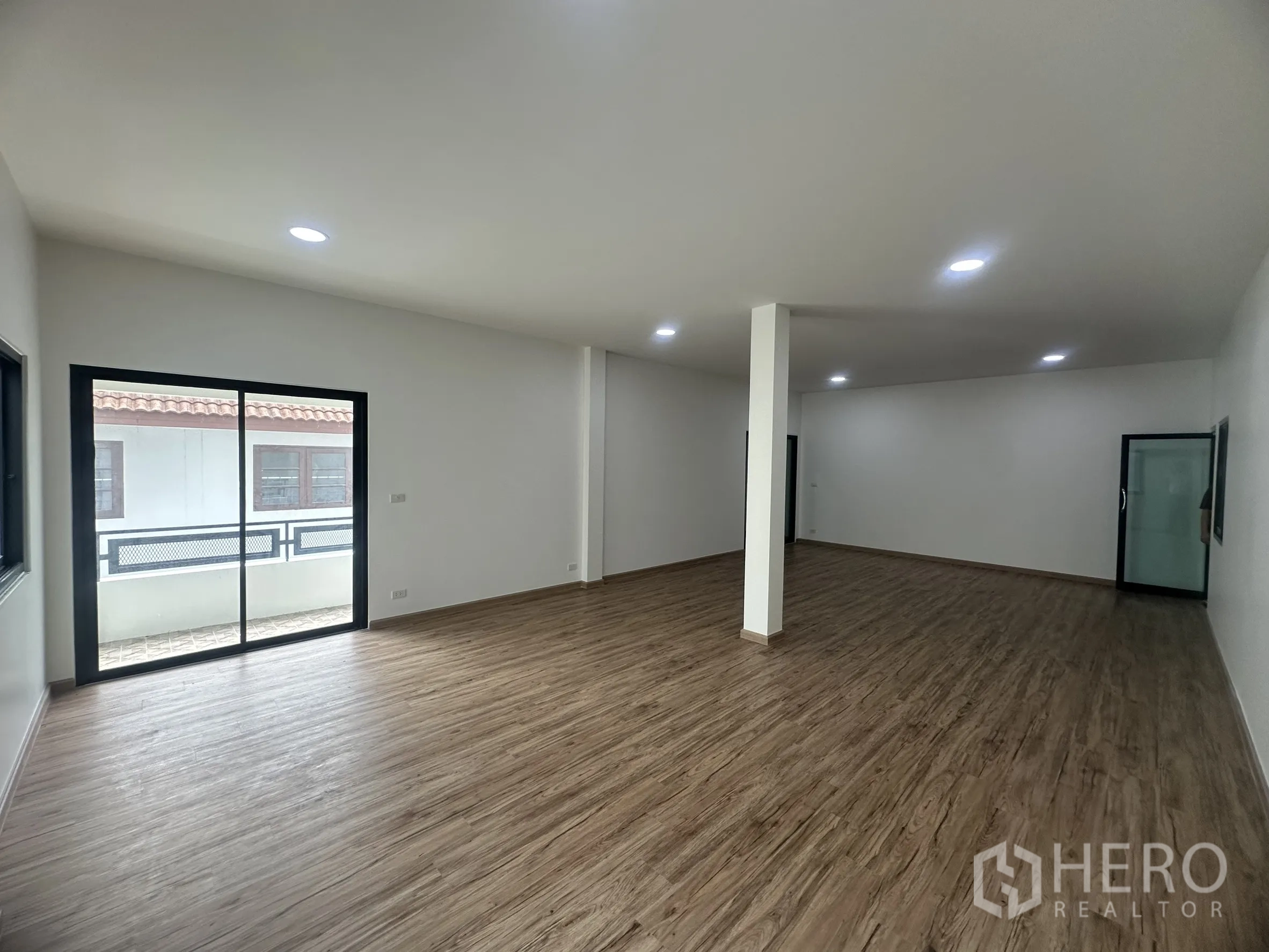Warehouse for sale in Khlong Luang, Pathum Thani - Office level showing a sliding glass door to a small balcony and a large open workspace.