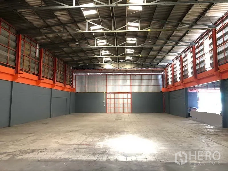 Factory for rent in Phra Pradaeng, Samut Prakan - Spacious warehouse interior with high steel truss roof, skylights, and open clear-span floor.
