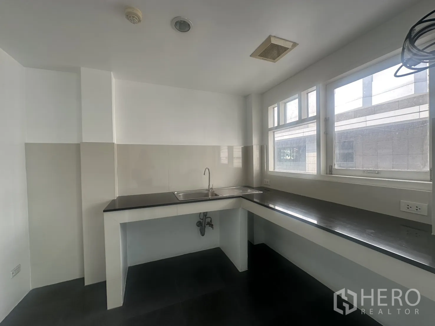 Office Space for rent in Watthana, Bangkok - Pantry with long countertops, sink, windows, and power outlets.