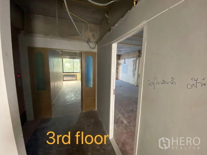 Shophouse for rent in Bang Rak, Bangkok - Third-floor corridor with double wooden doors leading to a bright room
