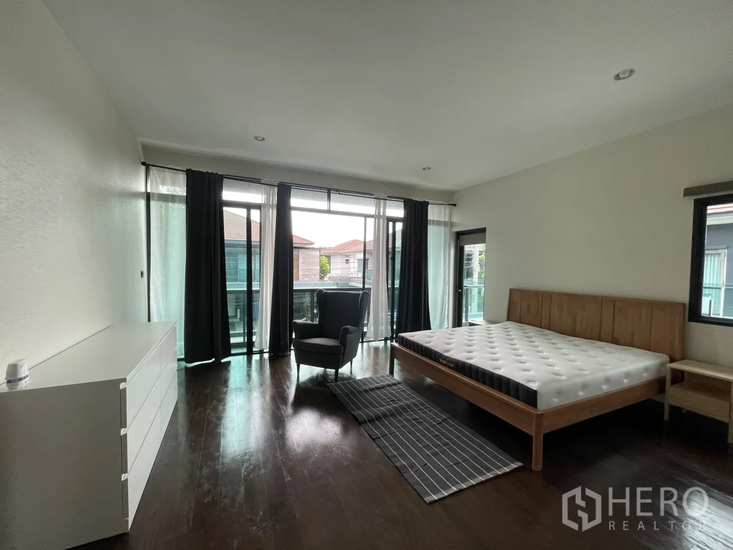 Detached House for rent in Bang Kapi, Bangkok - Master bedroom with balcony doors, king bed and dresser.