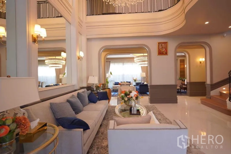 Detached House for sale in Bang Kapi, Bangkok - Grand foyer with double-height ceiling, curved staircase, and seating.