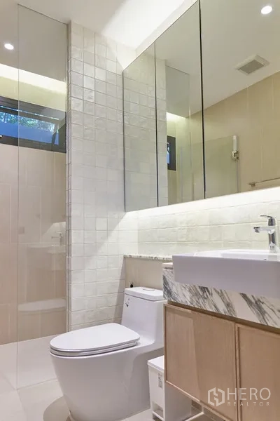 Detached House for rent in Watthana, Bangkok - Contemporary bathroom with expansive mirrors, glass shower and sleek vanity.