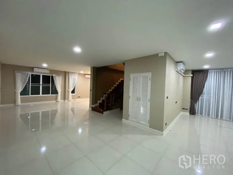Detached House for rent in Prawet, Bangkok - Spacious ground-floor living space with multiple windows, air conditioners and central column.