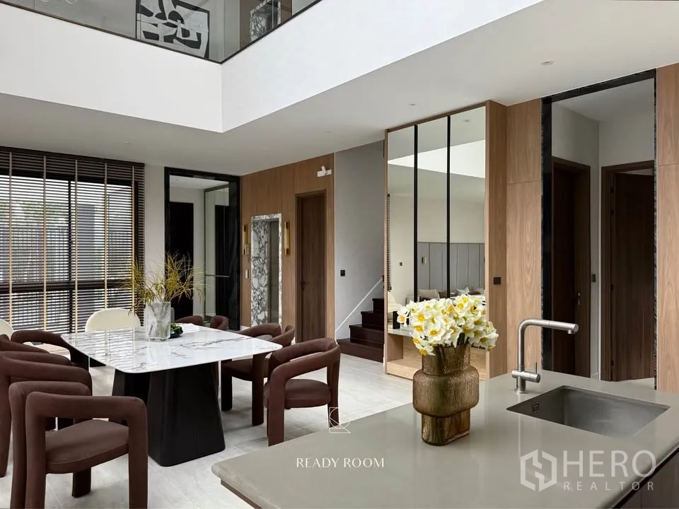 Detached House for rent in Bang Kapi, Bangkok - Kitchen island outlook to dining area with mirrors, stairs and wood accents.