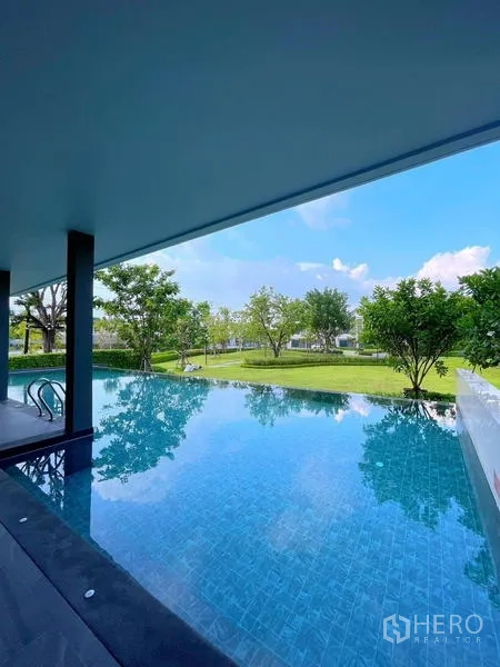 联排别墅 出租在Bang Phli, Samut Prakan - 花园旁室外泳池，蓝色马赛克池面。