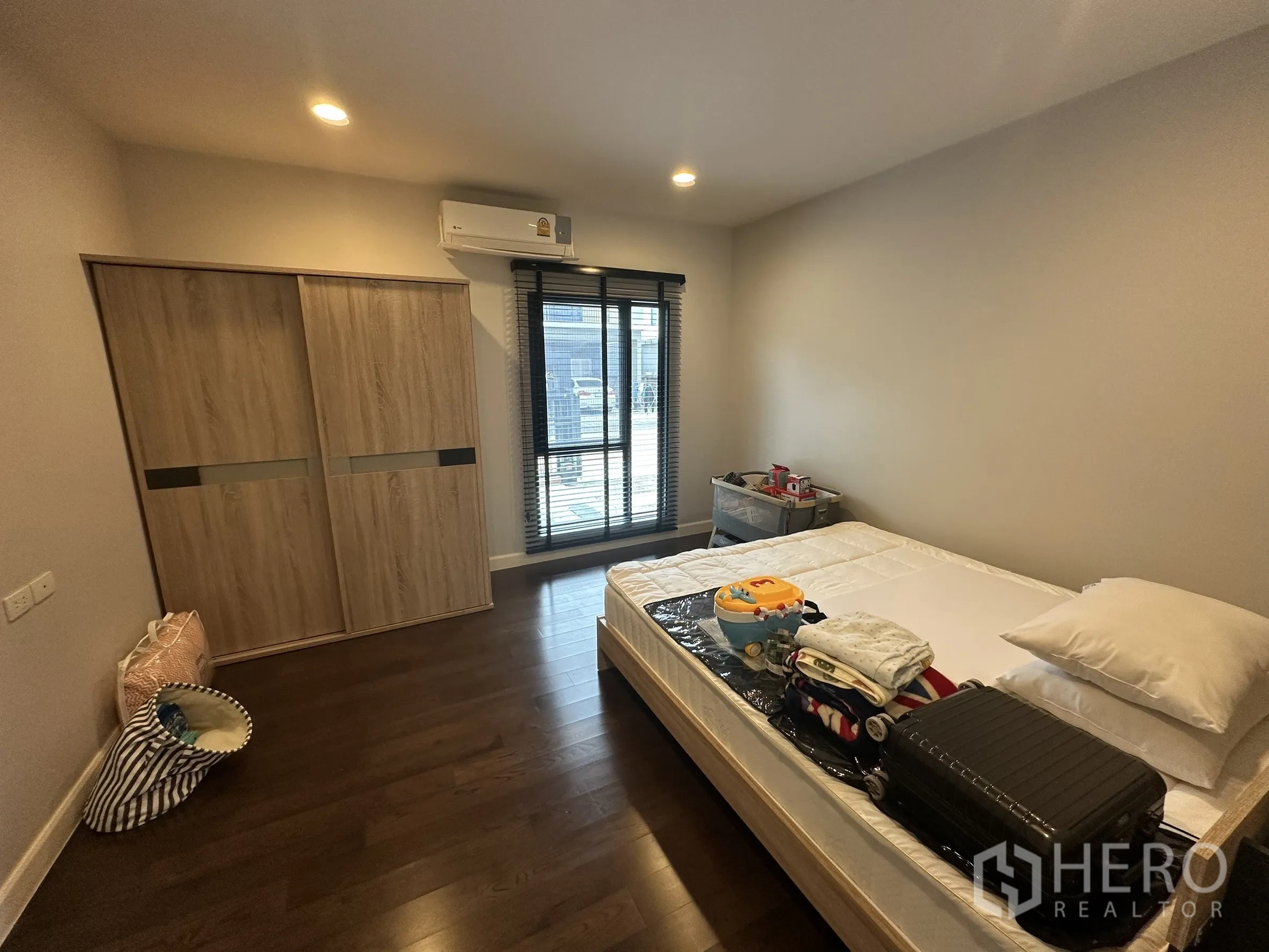 Detached House for rent in Lam Luk Ka, Pathum Thani - Bedroom with sliding wardrobe, wood floor and balcony-style window.