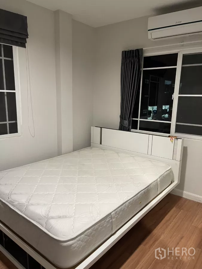 Detached House for rent in Bang Kapi, Bangkok - Third bedroom with platform bed and black sideboard beside the window.