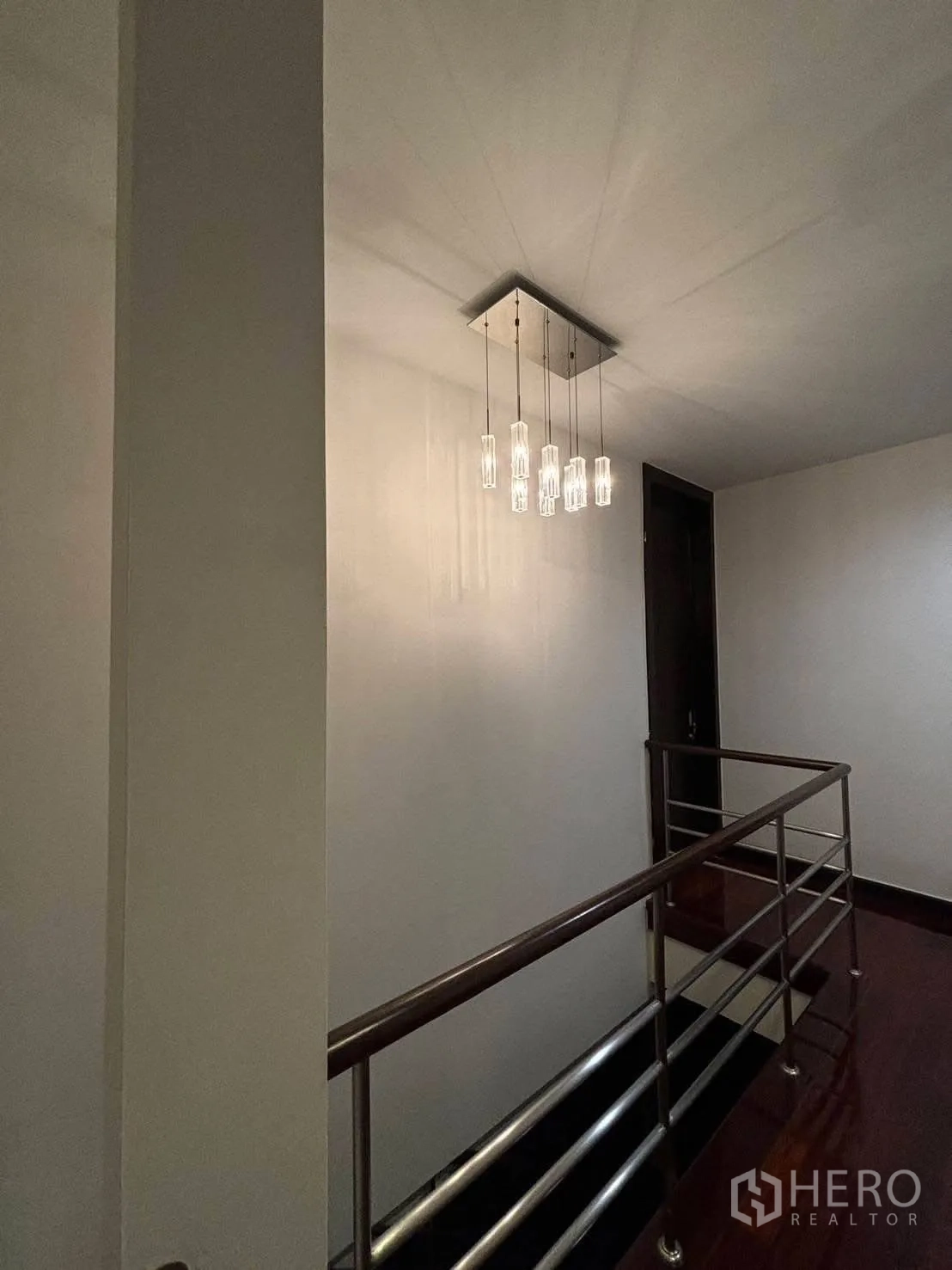 Detached House for rent in Bang Kapi, Bangkok - Stair landing with modern pendant chandelier and steel railing.