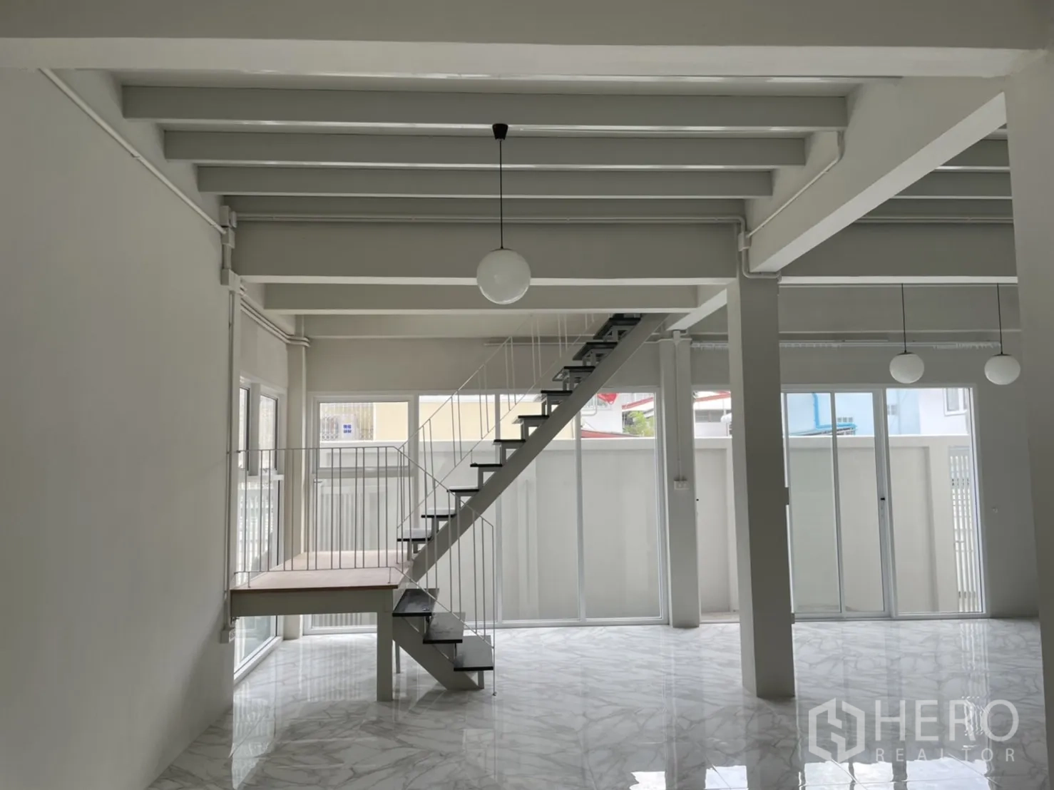 Detached House for rent or sale in Din Daeng, Bangkok - Open-plan living area with marble-look floors and steel staircase to the upper level.