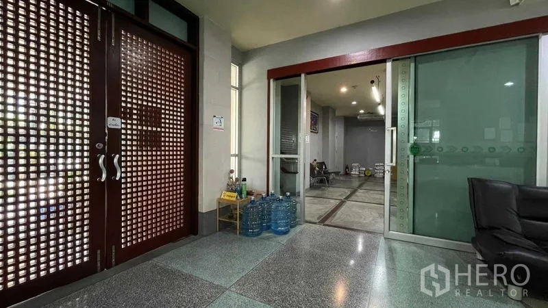 Warehouse for rent or sale in Bangkok Yai, Bangkok - Reception area with sliding glass doors and seating adjoining warehouse offices.