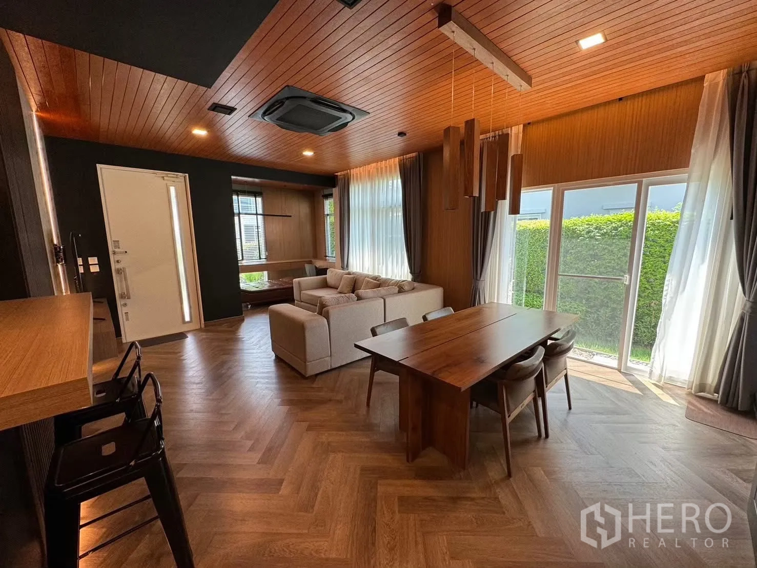 Detached House for rent in Prawet, Bangkok - Modern closed kitchen with wood countertops, black cabinets and gas hob.