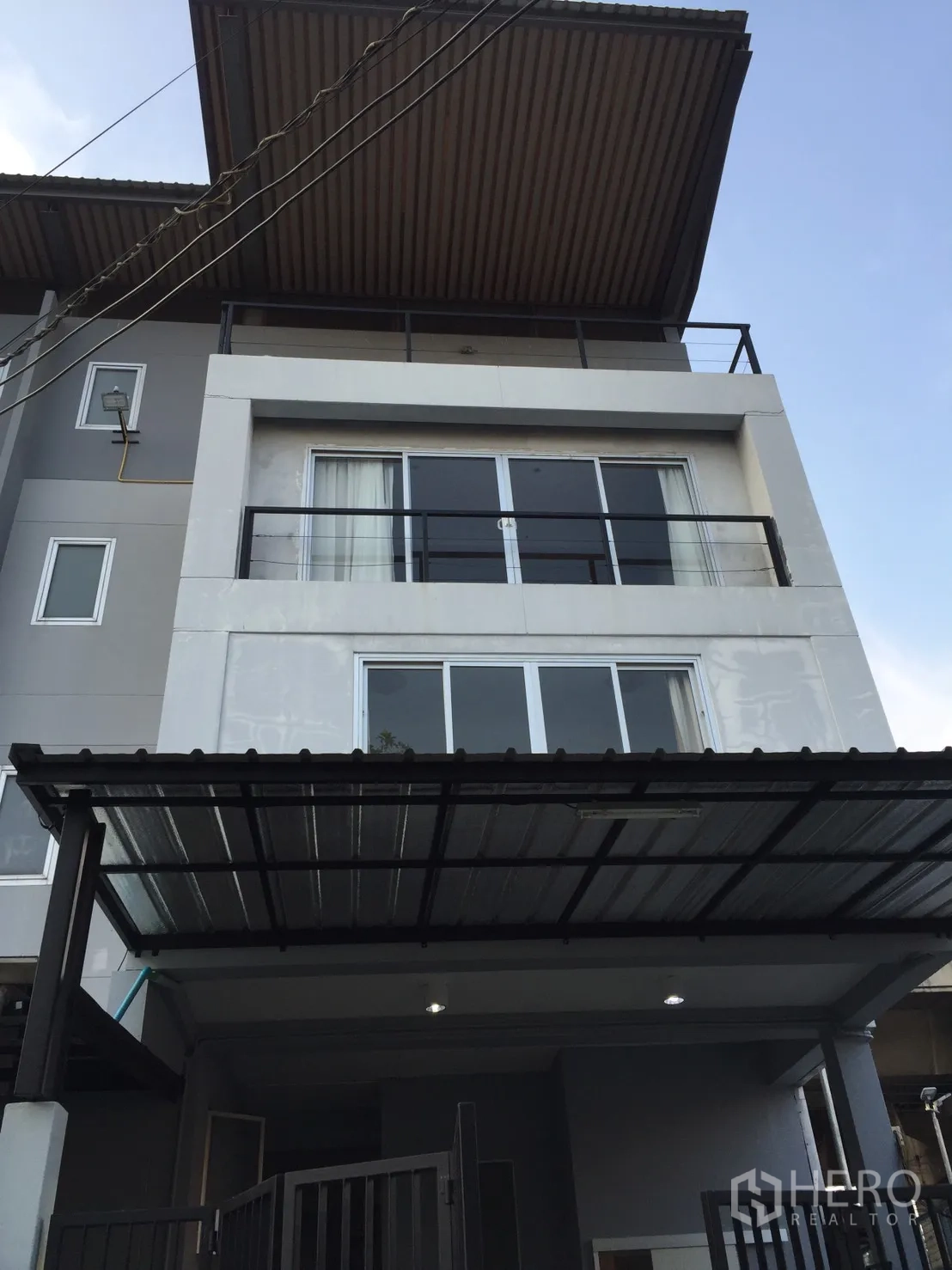 Home Office for rent or sale in Suan Luang, Bangkok - Modern three-storey home office facade with balconies and a covered carport.