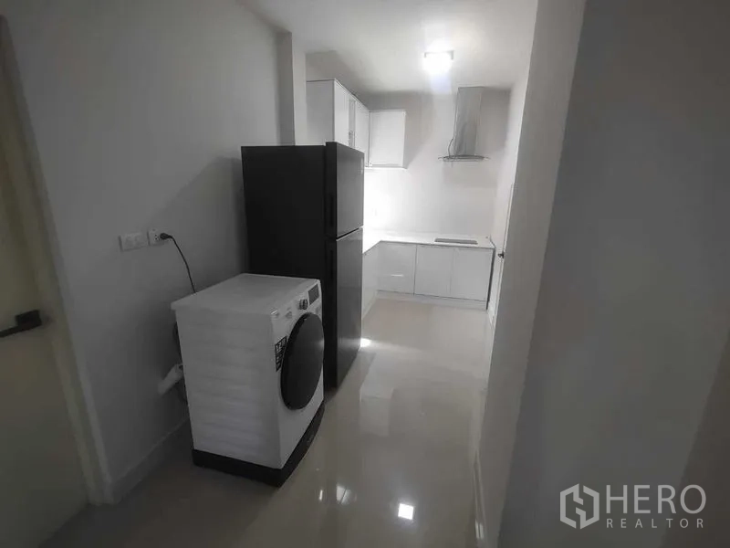 Detached House for rent in Khan Na Yao, Bangkok - Utility corridor with refrigerator and washing machine leading to the kitchen.