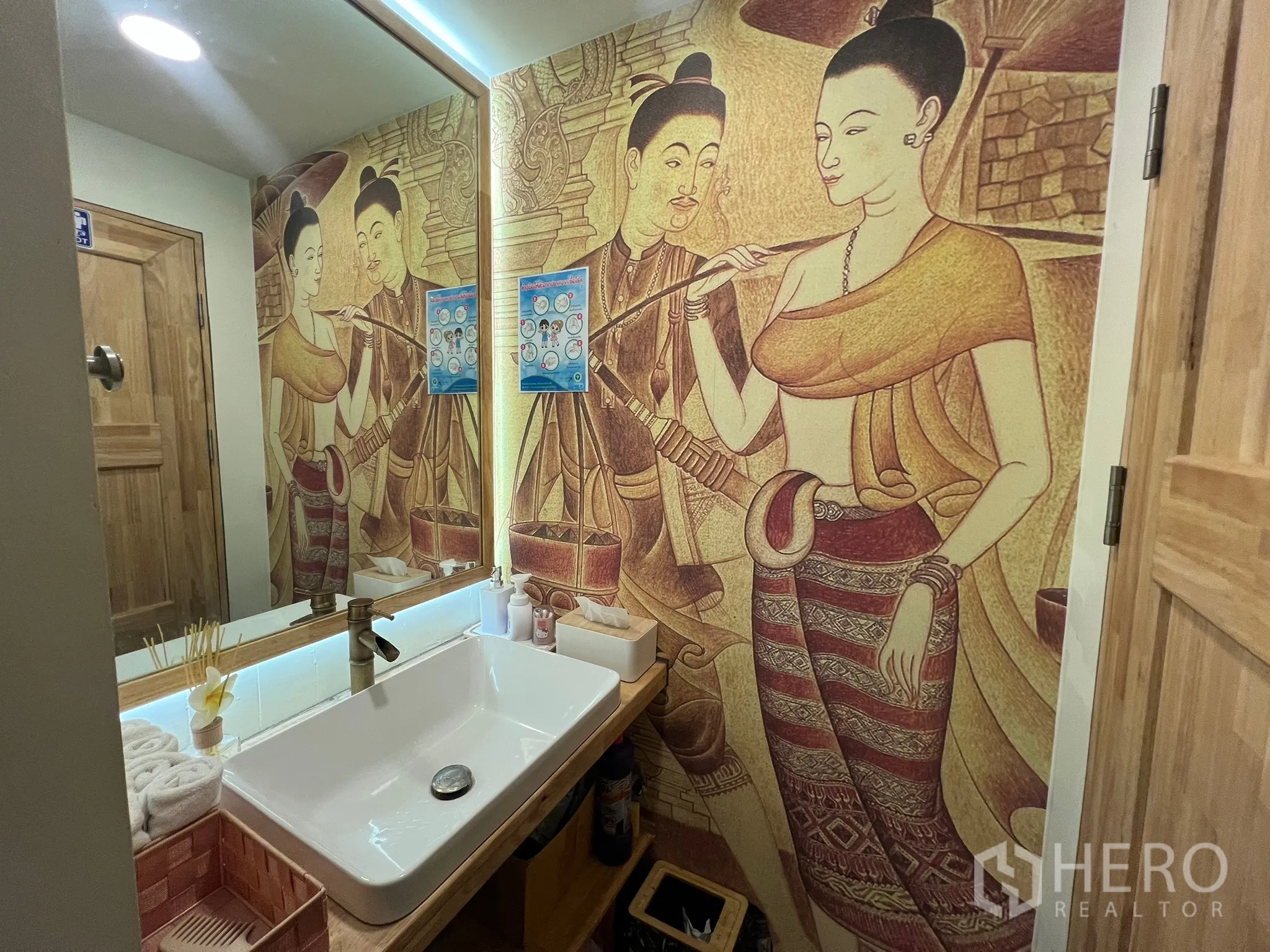 Retail Space for rent in Khlong Toei, Bangkok - Washroom vanity with wide mirror, modern sink and decorative mural wall.