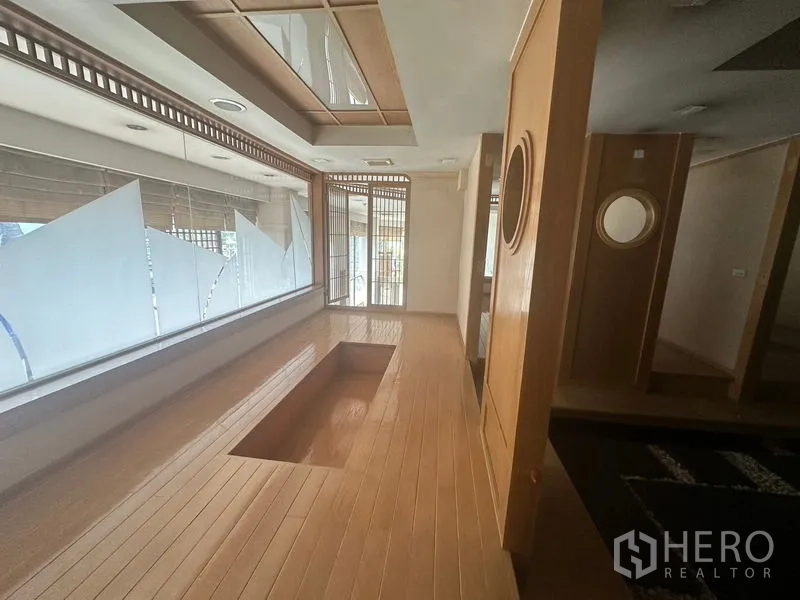 Retail Space for rent in Bang Rak, Bangkok - Wood-paneled corridor with large windows and a recessed seating platform in Japanese style.