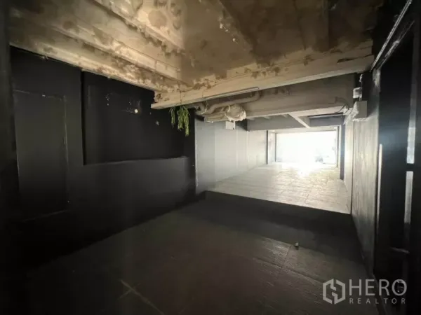 Retail Space for rent in Watthana, Bangkok - Open-plan retail interior with tiled ramp, exposed ceiling pipes, and dark feature walls.