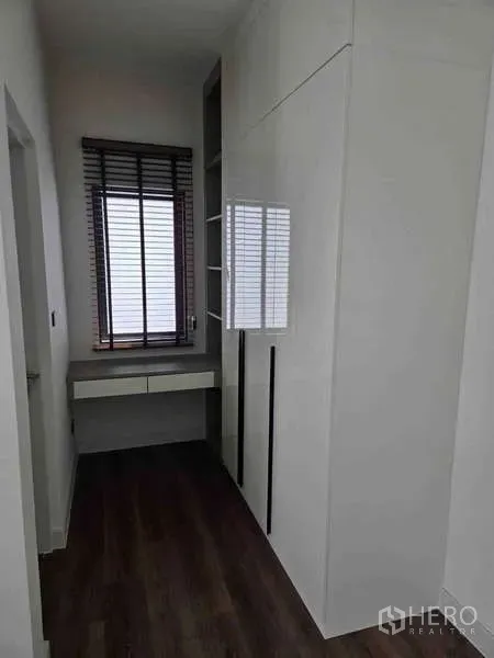 独立式住宅 出租在Bang Phli, Samut Prakan - 更衣走廊，白色一体柜、书桌与百叶窗。