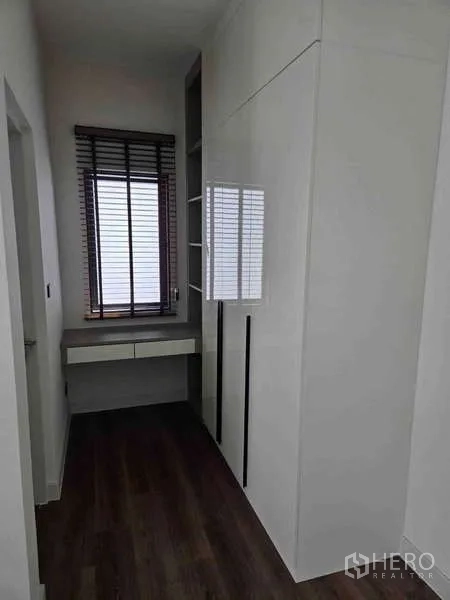 独立式住宅 出租在Bang Phli, Samut Prakan - 更衣走廊，白色一体柜、书桌与百叶窗。