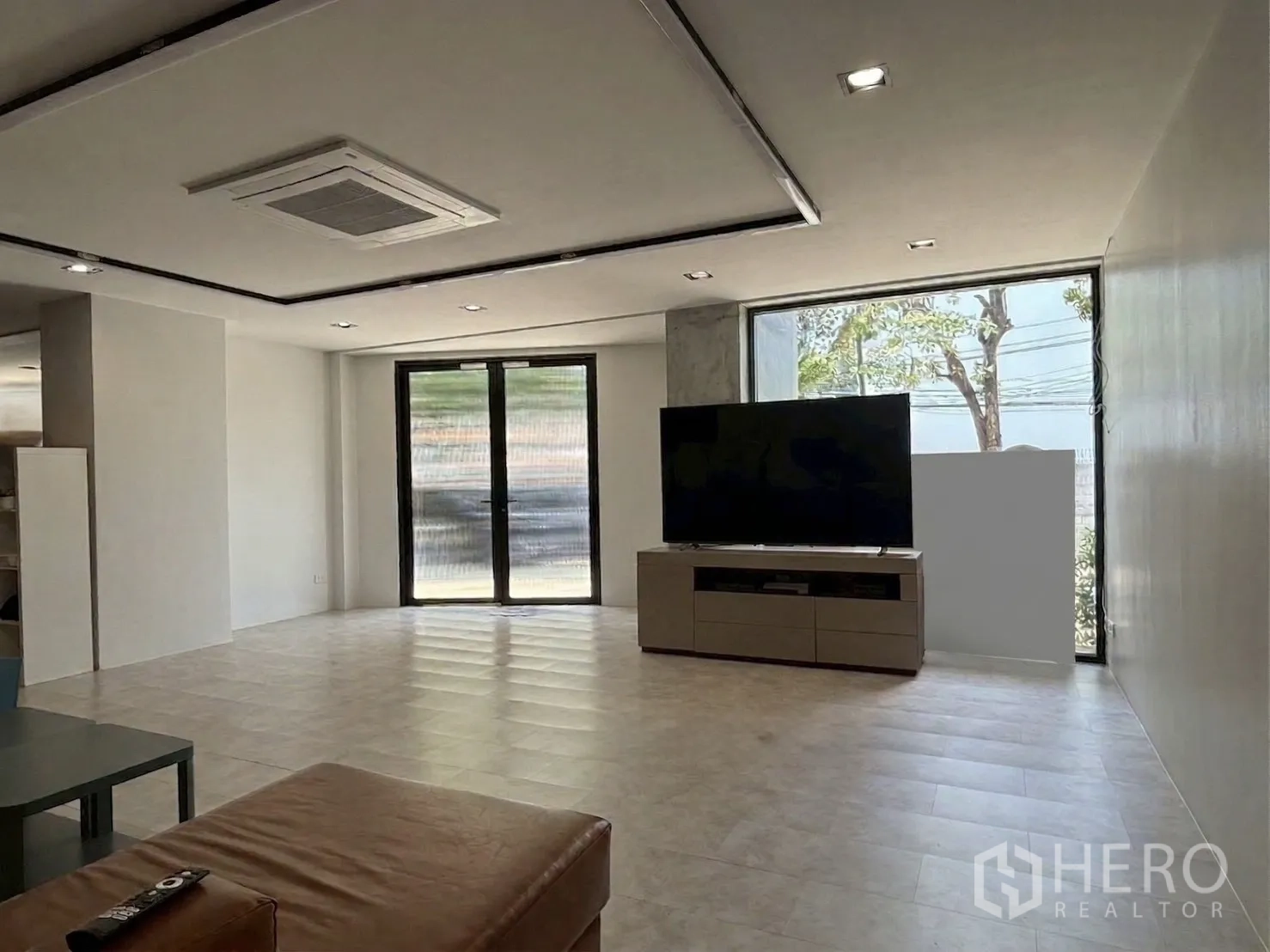 โฮมออฟฟิศ for rent in Watthana, Bangkok - โถงรับแขกชั้นล่างมีทีวีขนาดใหญ่และประตูกระจก