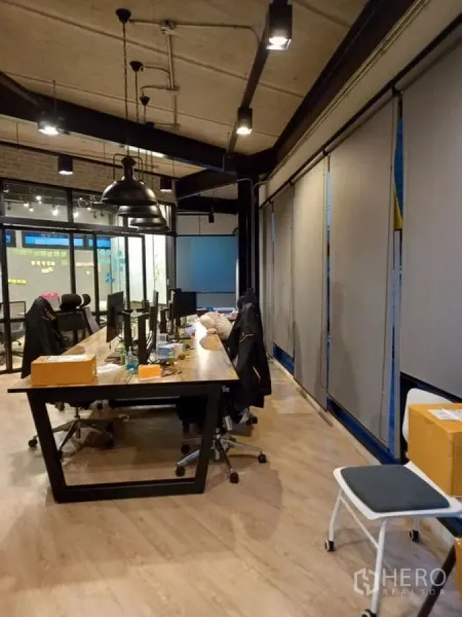 Office Space for rent in Chatuchak, Bangkok - Long collaborative table beside floor-to-ceiling windows with blinds.