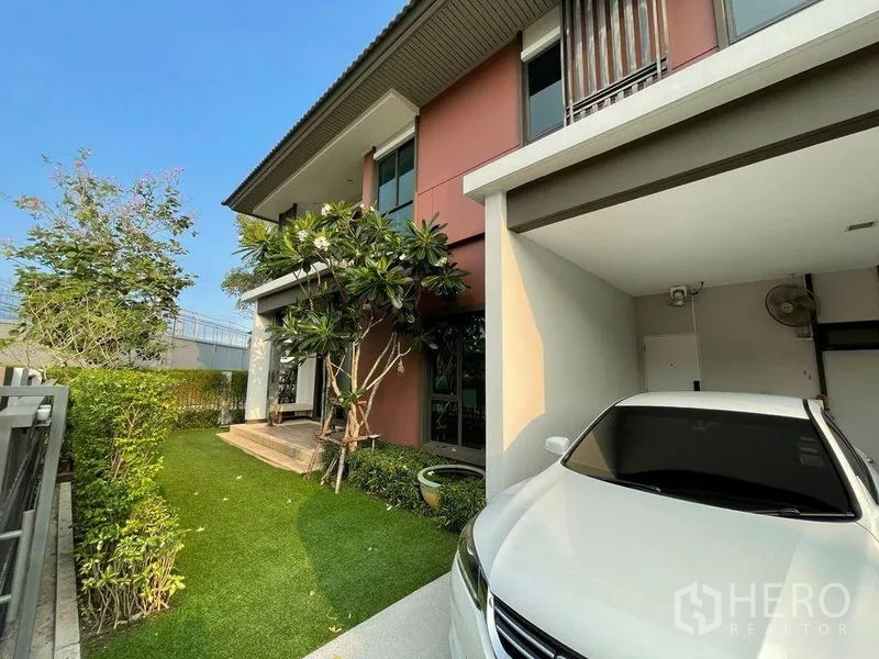 Detached House for sale in Pak Kret, Nonthaburi - Two-storey house exterior with covered carport and manicured front garden.